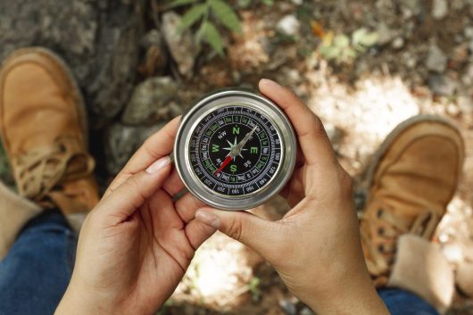 top-view-woman-holding-compass